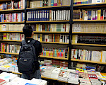 Man looking at a tall shelf of books