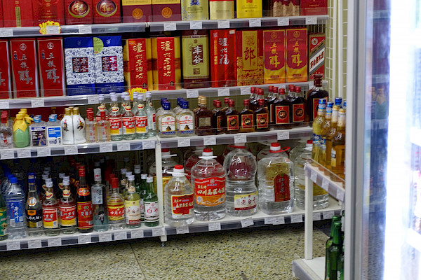 Crowded shelf of bottles of alcohol